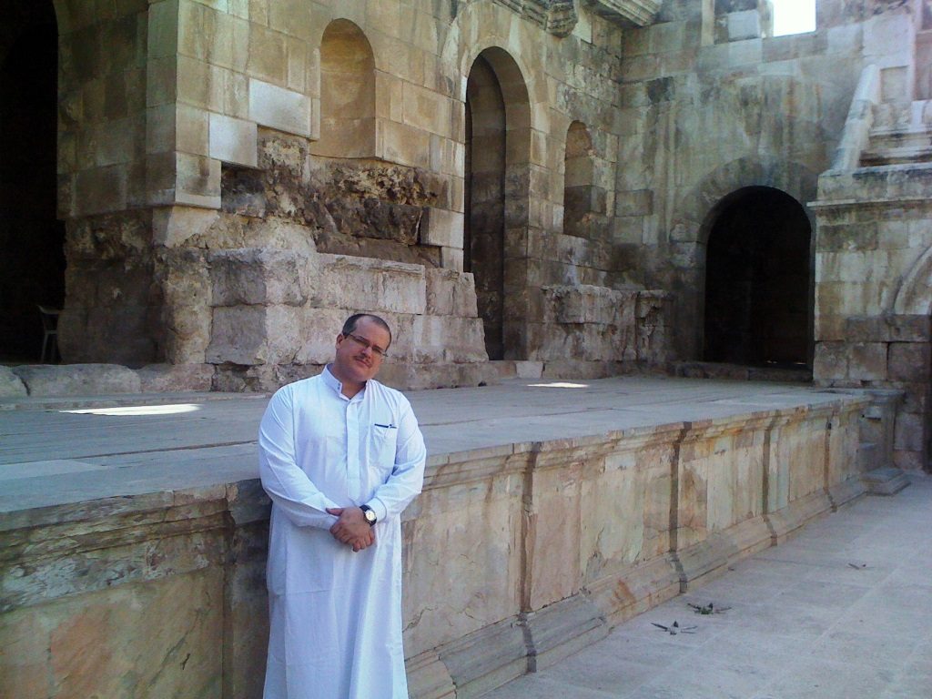 Fernando Báez beside an ancient stone wall